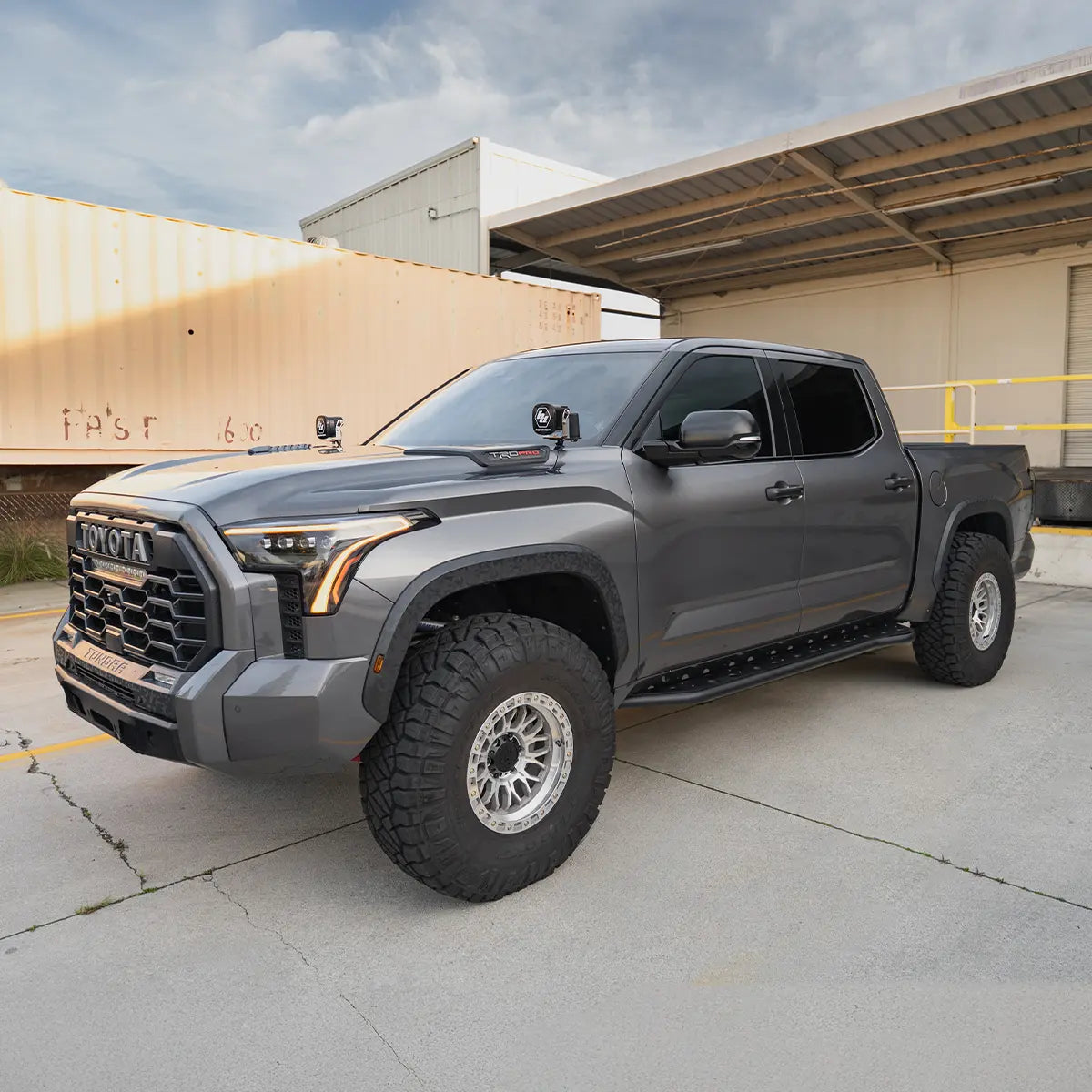 Gray Toyota truck parked in front of a building with a clear sky.