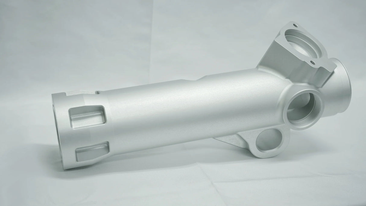 Metallic cylindrical component on a gray background