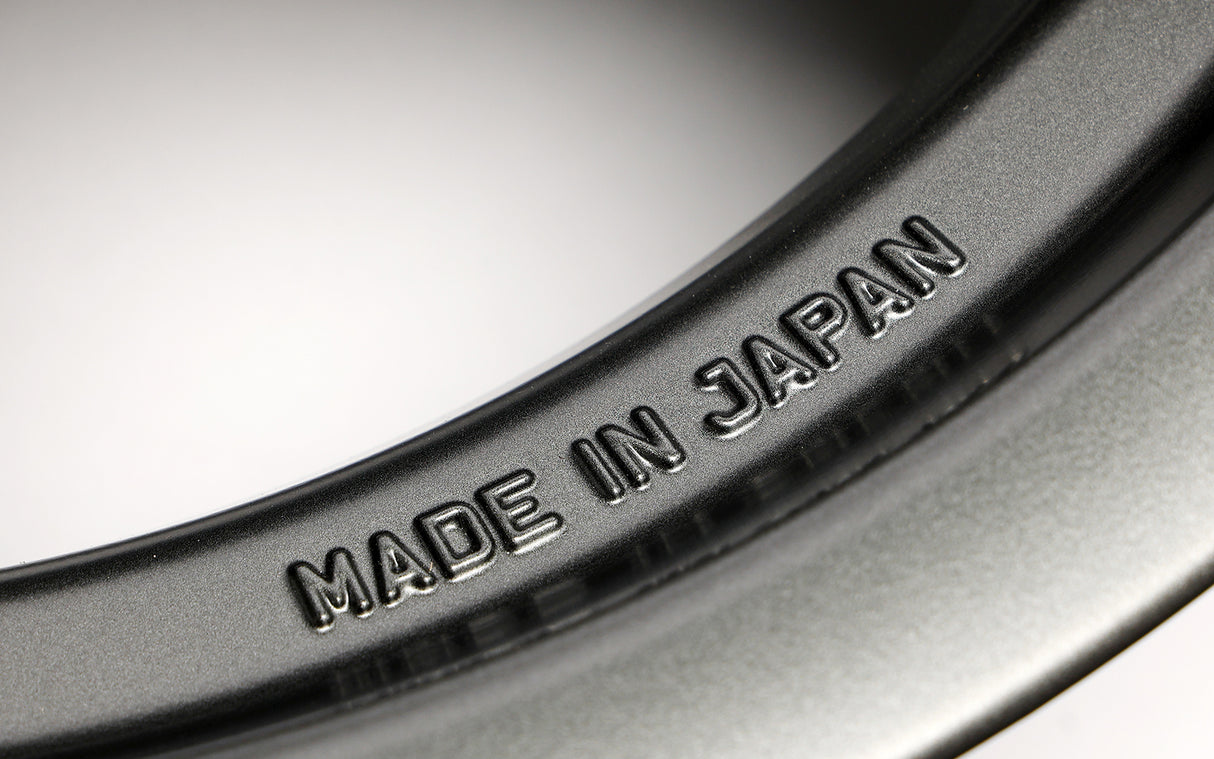 Close-up of a rim with 'MADE IN JAPAN' engraving on a metallic surface.