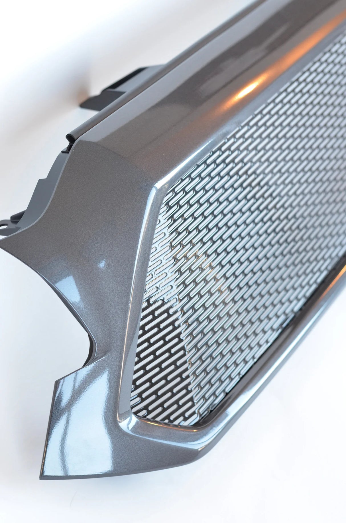 Close-up of a car grille with a textured pattern on a white background