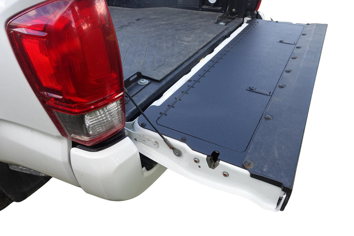 Truck bed with a flatbed cover attached, showing the tail light on a white background.