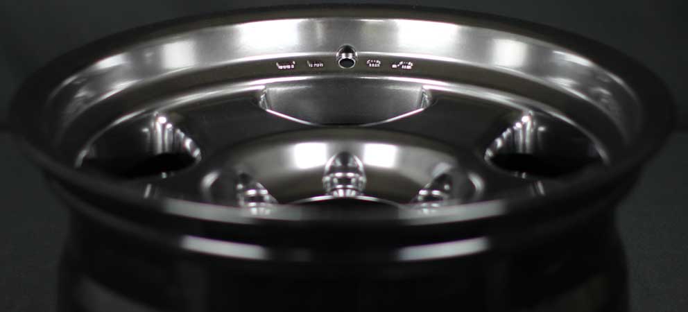 Face 4 Deep. Close-up of a shiny metallic wheel rim on a dark background