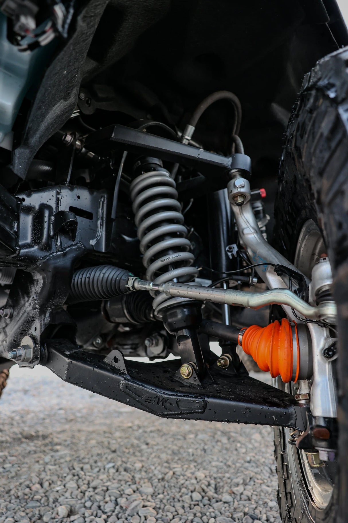 Close-up of a vehicle's suspension system with an orange shock absorber.