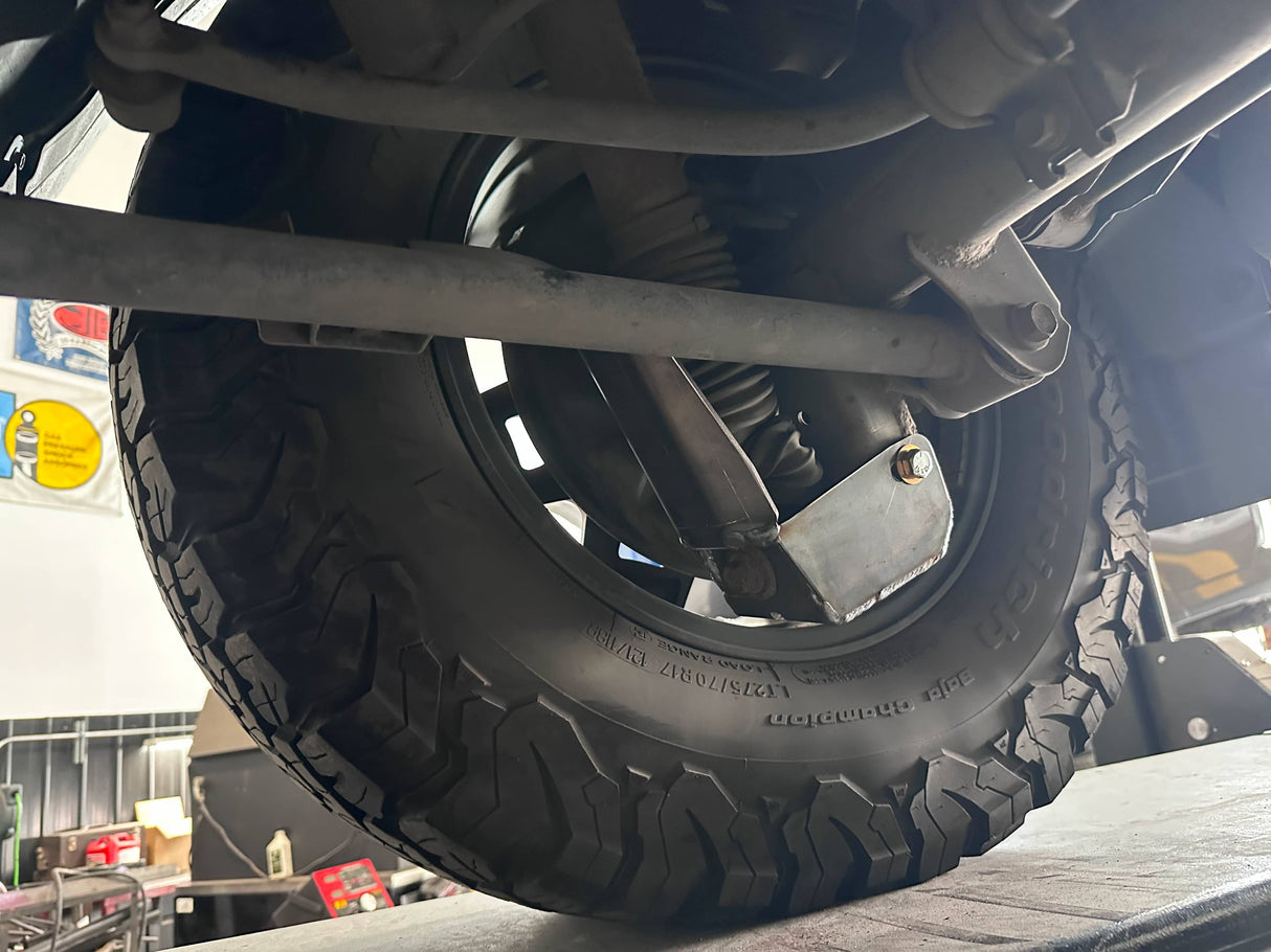 Close-up of a tire and suspension system on a vehicle.