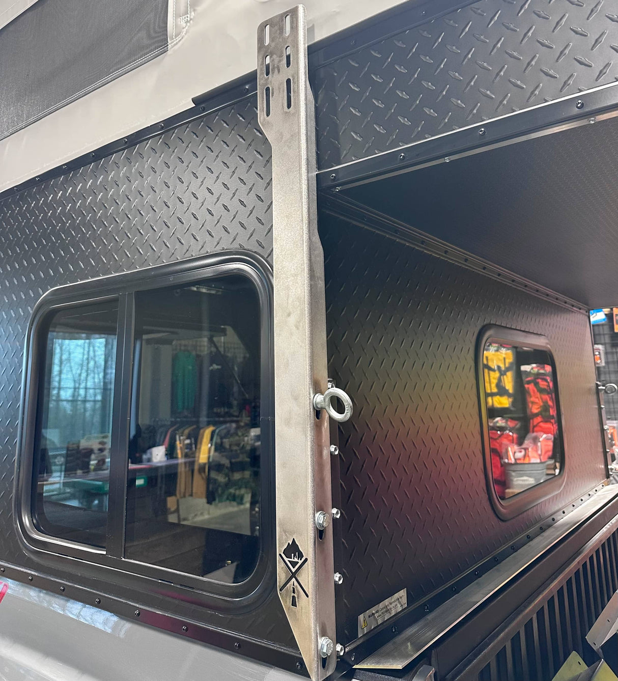 Metal awning bracket on black Project M camper