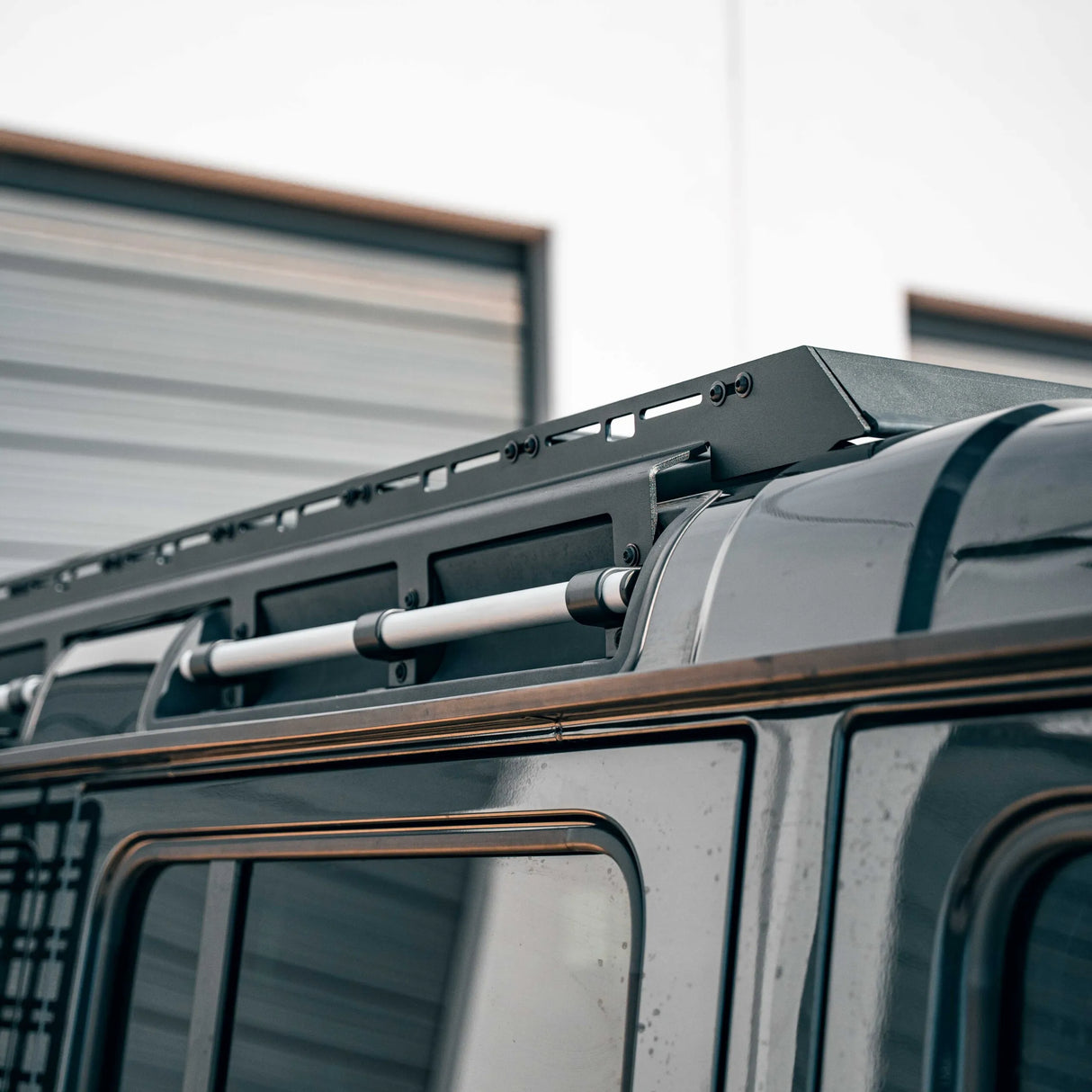 Close-up of a vehicle roof rack system on a truck with a blurred background.