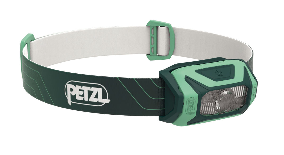 A green and white Petzl Tikkina headlamp with a compact design and adjustable headband.