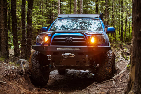 Blue Toyota Tacoma Off Roading in the Forest