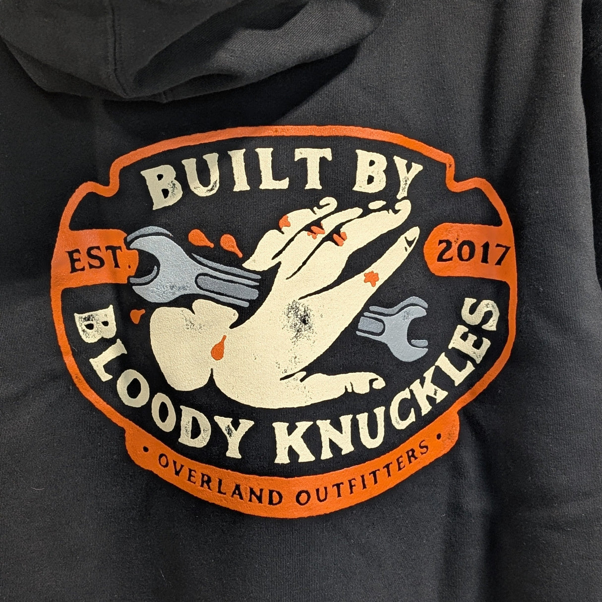 Black hoodie with 'Built by Bloody Knuckles' logo on a dark background