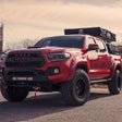 Angled red Tacoma sits on pavement displaying 25 degree sliders bolted in place 
