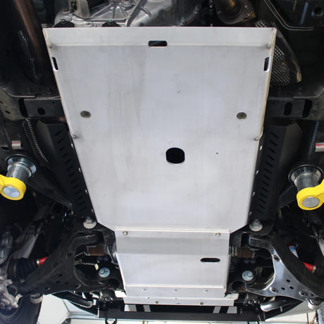 Metal engine guard or skid plate on a vehicle with visible bolts and components.