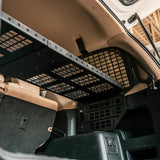 Car interior with a black cargo net and beige seats.