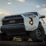 White 4Runner with off-road tires on a dirt road with Amber Fog Lights