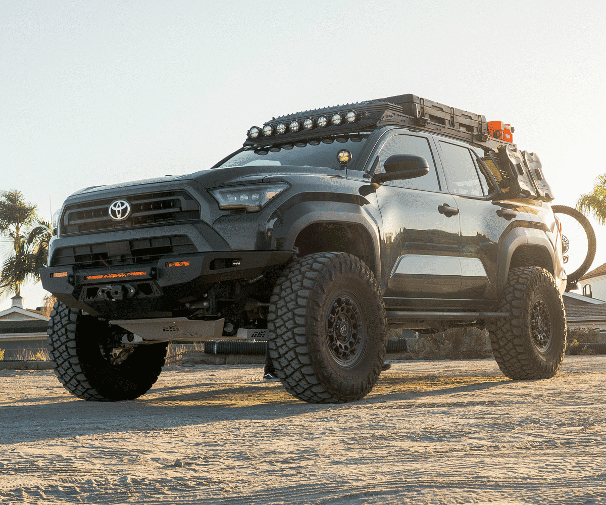 Black Toyota truck with off-road equipment on a dirt road