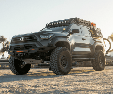 Black Toyota truck with off-road equipment on a dirt road