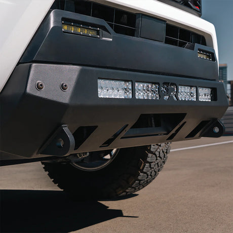 White Tacoma on pavement with stealth bumper
