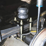 Close-up of a mechanical component with bolts and a metal rod.