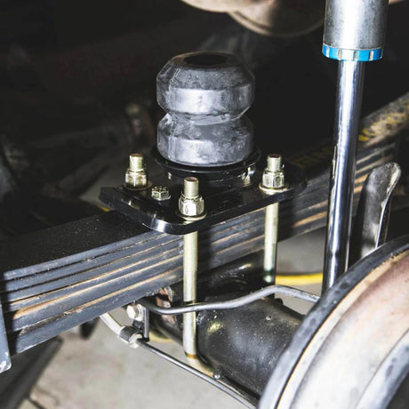 Close-up of a mechanical component with bolts and a metal rod.