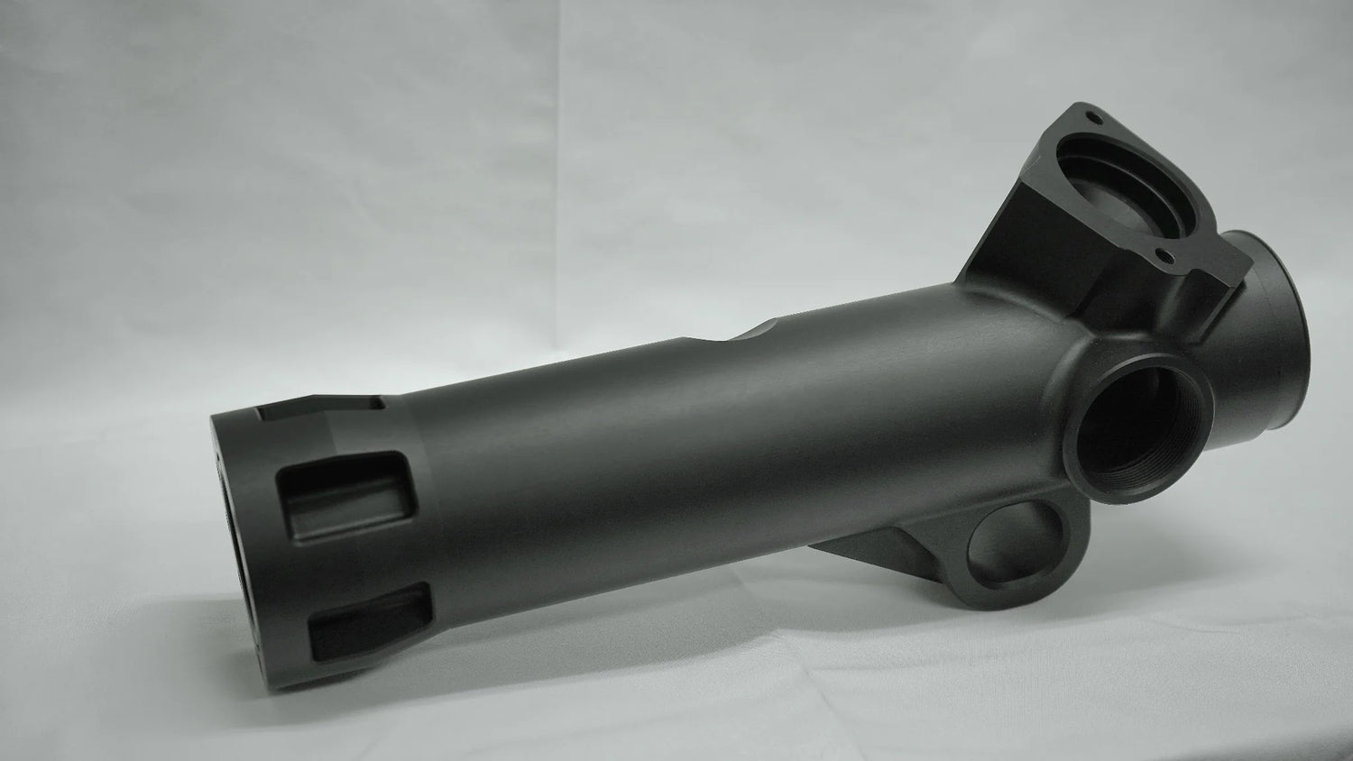 Black metal mechanical component on a gray background