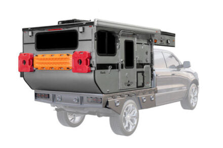 Four Wheel Campers Flatbed model on the bed of a flatbed truck