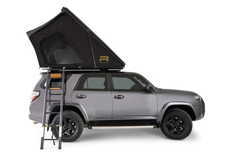 Gray SUV with a rooftop tent and ladder on a white background