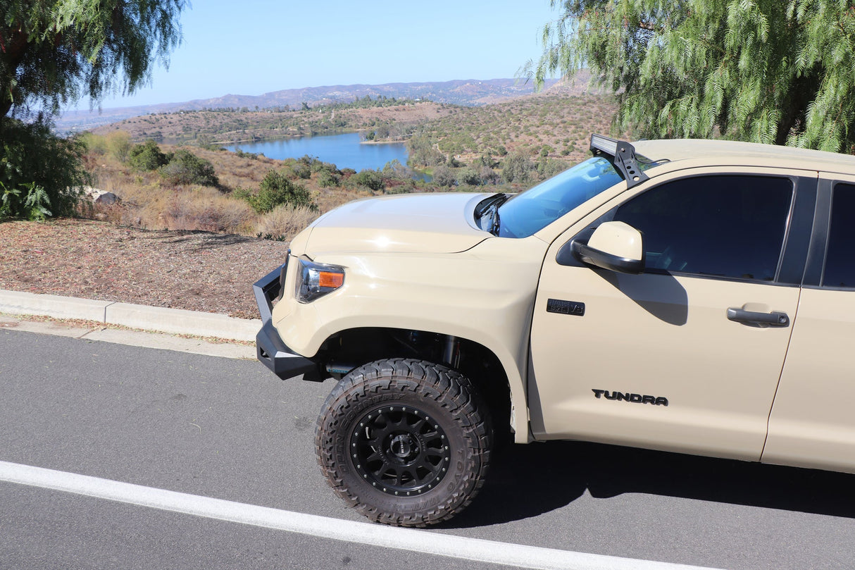 Beige Toyota Tundra truck parked on a road with a scenic background
