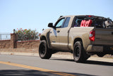Beige pickup truck on a road with a clear blue sky