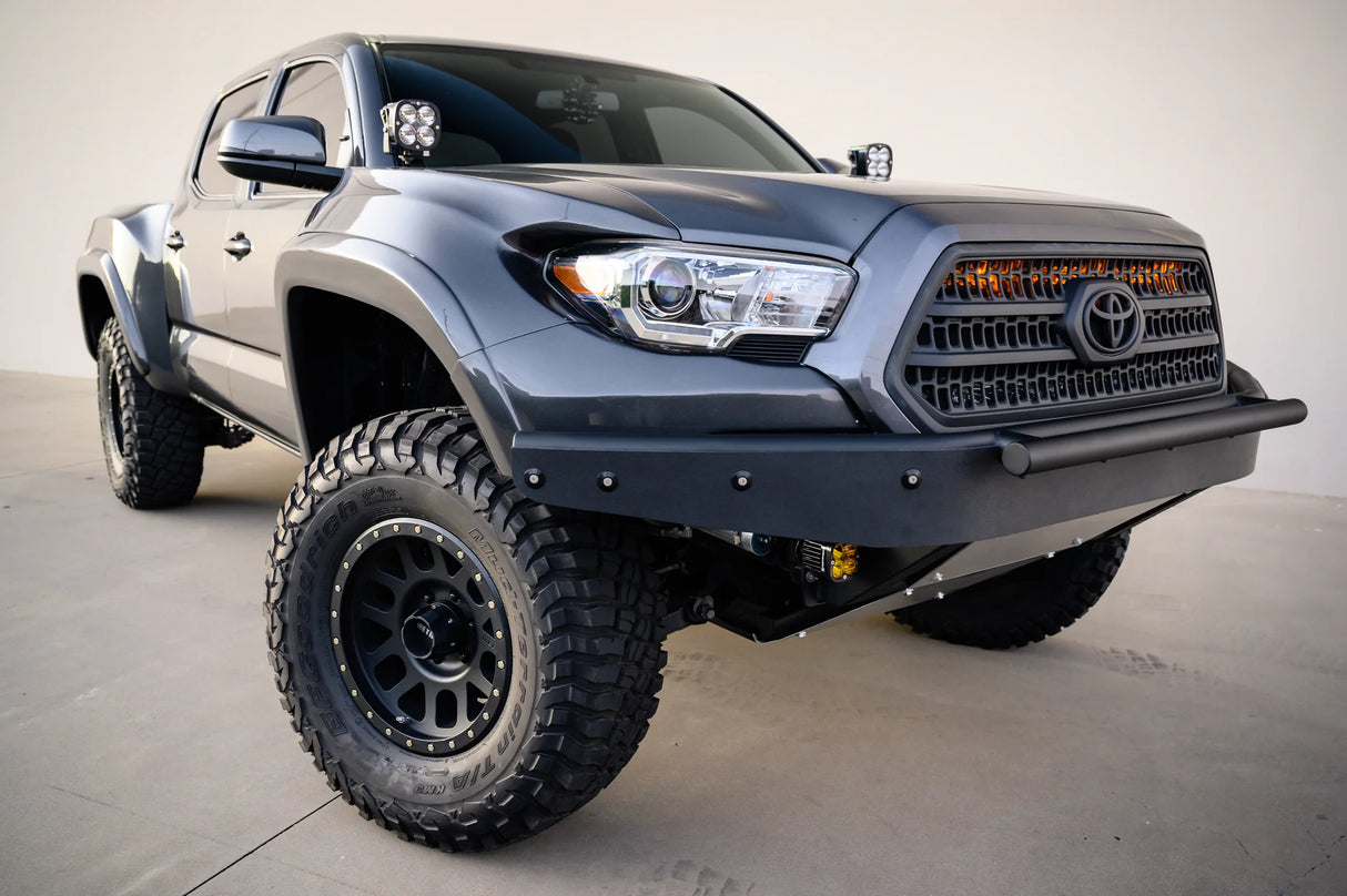 Gray Toyota truck with large off-road tires on a concrete surface