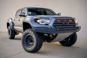 Gray Toyota truck with off-road tires on a concrete floor