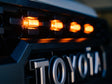 Close-up of a Toyota vehicle with illuminated amber lights on a dark background
