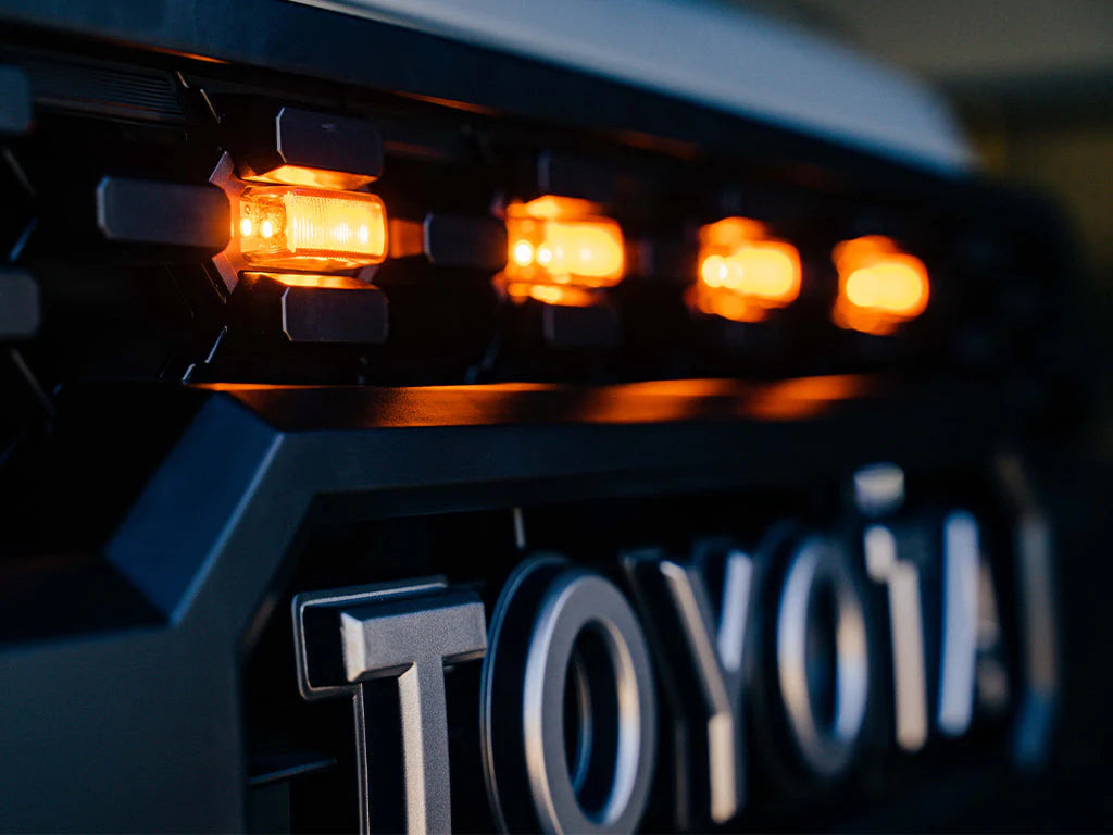 Close-up of a Toyota vehicle with illuminated amber lights on a dark background