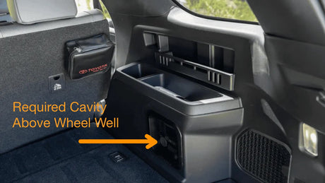 Car interior with a compartment labeled 'Required Cavity Above Wheel Well' pointing to a storage area.