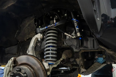 Close-up of a vehicle's suspension system with PEAK branding.
