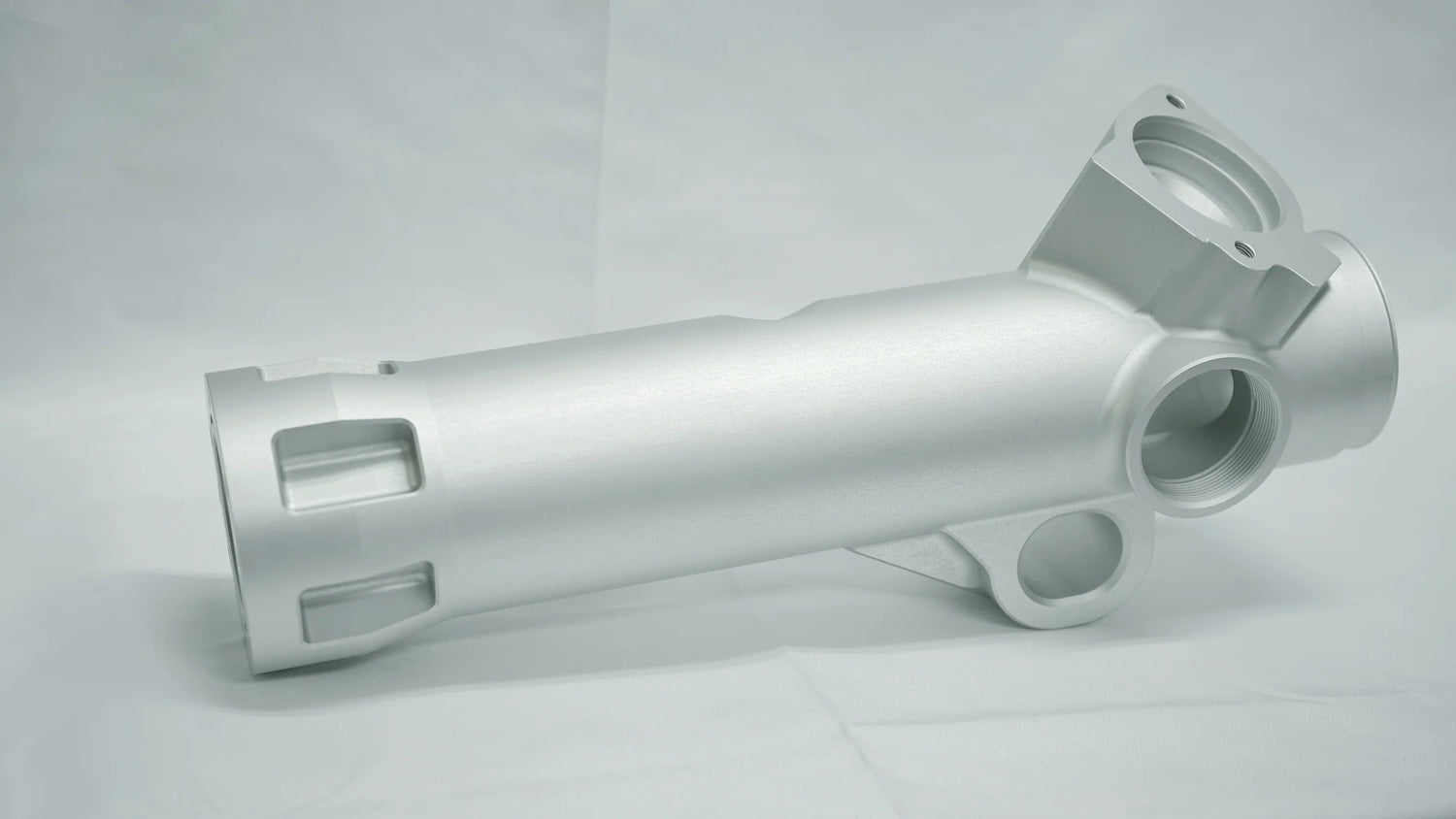 Metallic cylindrical component on a gray background