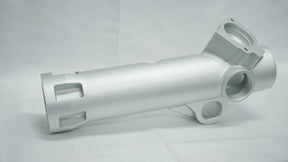 Metallic cylindrical component on a gray background