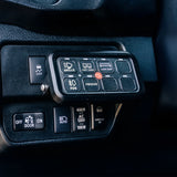 Control panel with various switches and indicators inside a vehicle