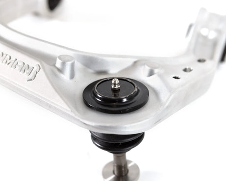 Close-up of a ball joint on an upper control arm with a brand logo on a white background