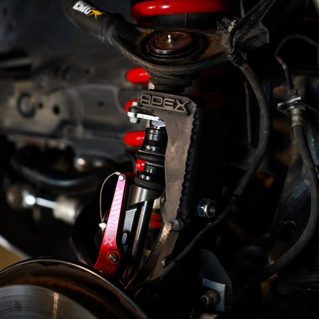 Close-up of a car suspension system with 'APEX' branding.
