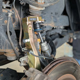 Close-up of a vehicle suspension system with Apex and Lukx branding.