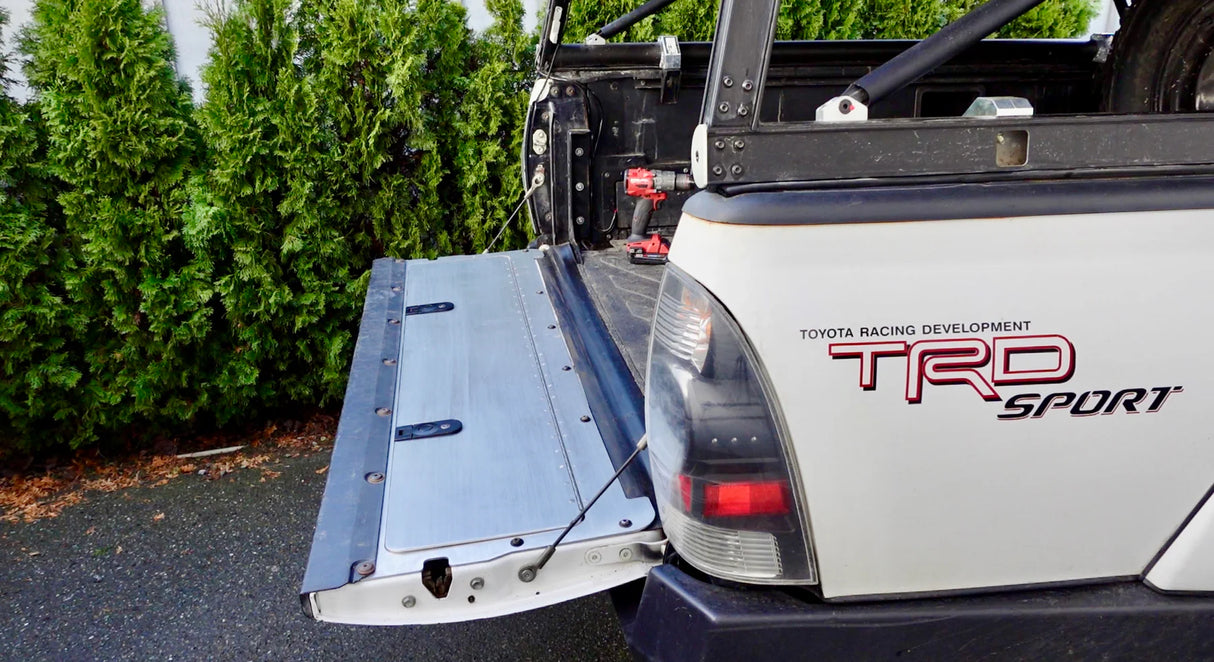 Toyota TRD Sport truck with an open tailgate in a driveway.