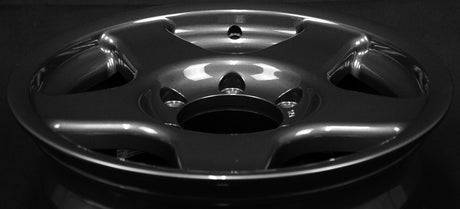 Face 1. Close-up of a shiny metallic rim on a black background