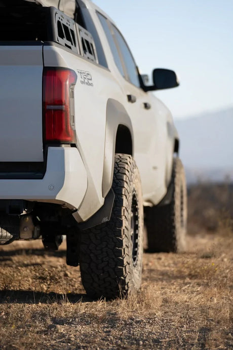 White off-road truck with large tires on a grassy field