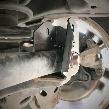 Close-up of a vehicle suspension system with a metal bracket.