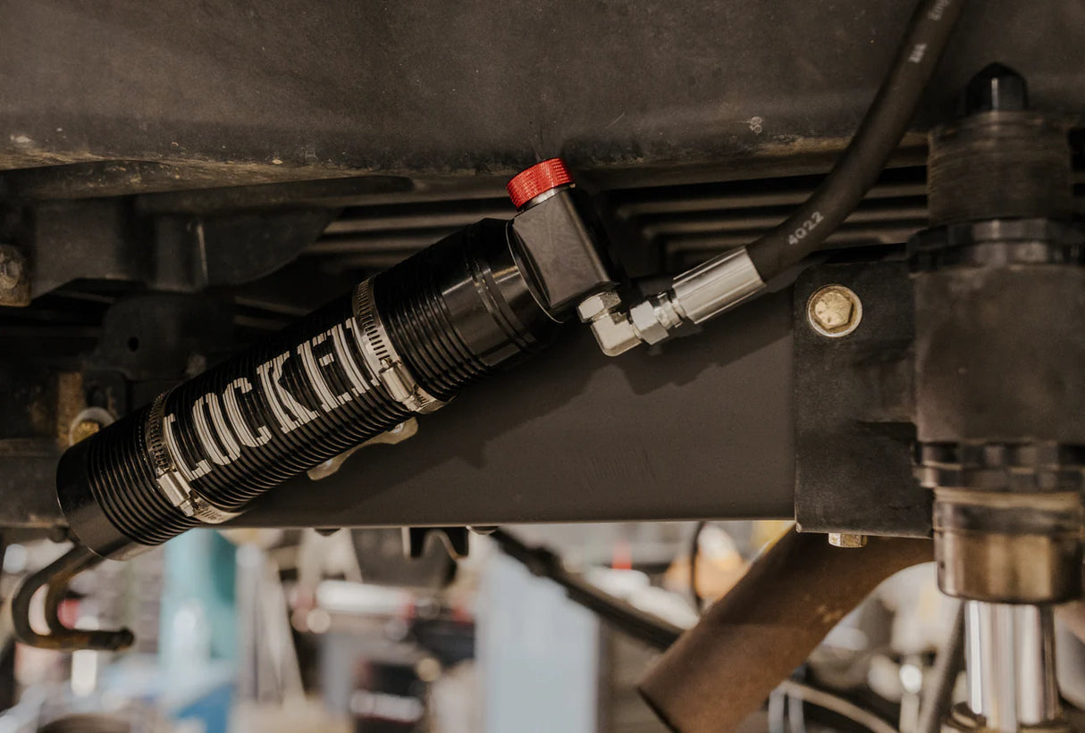 Close-up of a shock absorber with 'Locked' branding on a vehicle's undercarriage.