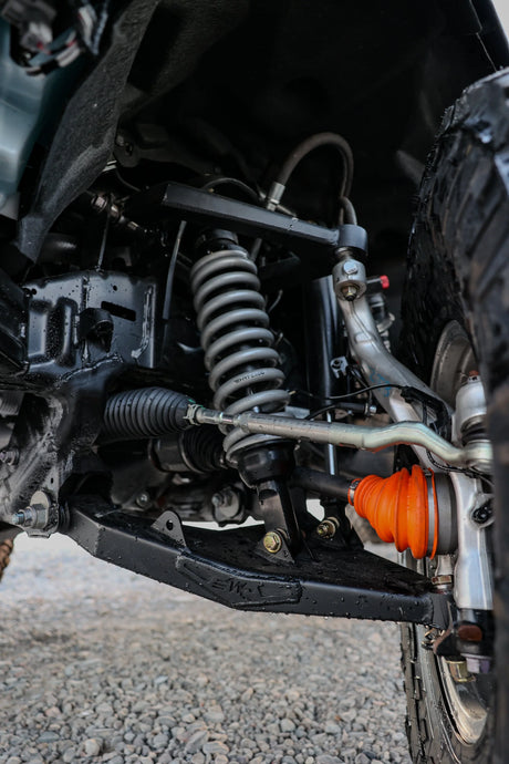 Close-up of a vehicle's suspension system with an orange shock absorber.
