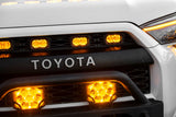 Close-up of a Toyota vehicle's front grille with illuminated LED lights.