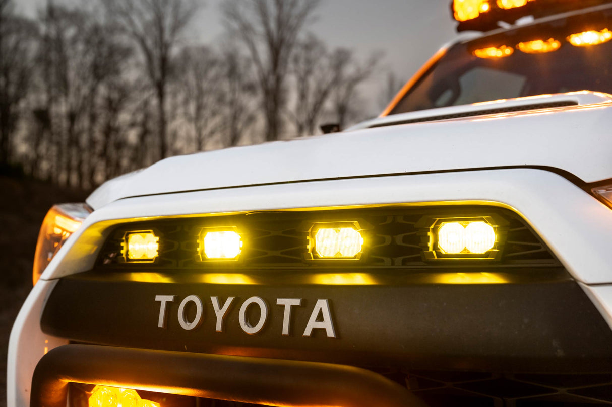 Close-up of a Toyota vehicle with illuminated headlights and warning lights.