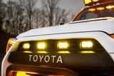 Close-up of a Toyota vehicle with illuminated headlights and warning lights.