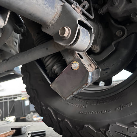 Close-up of a vehicle suspension system with a tire and wheel.