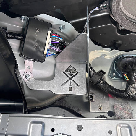 Close-up of a mechanical component with wiring and metal bracket inside a vehicle.